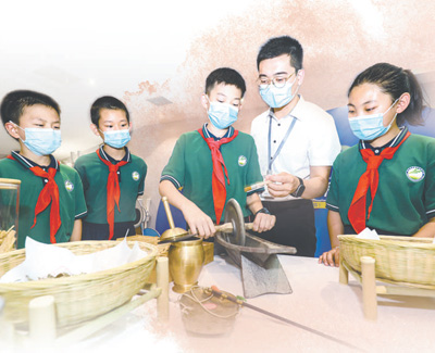 河北省石家莊市樂仁堂中醫(yī)藥健康科普館內(nèi)，小學(xué)生在學(xué)習(xí)鐵藥碾使用方法。梁子棟攝（人民視覺）